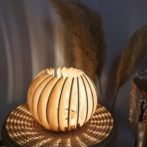 Parametric wooden ball lamp with curved slats on a woven surface